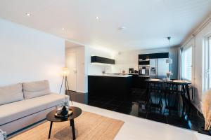 a living room with a couch and a kitchen at Arctic Circle Holiday Homes in Rovaniemi