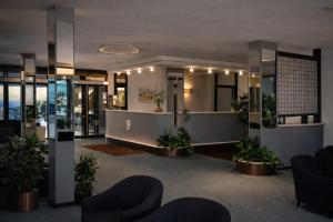 a lobby with plants and chairs in a building at Hotel Granducato in Montepulciano