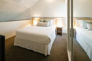 a hotel room with two beds and a mirror at The Leea, Darwin in Darwin +109 photos