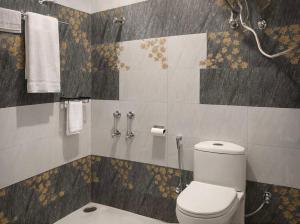 a bathroom with a toilet and some towels at Milana Ashram in Jari
