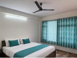 a bedroom with a bed and a ceiling fan at Milana Ashram in Jari