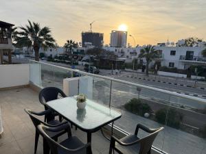 a table and chairs on a balcony with a view of a city at 777 Stars in Paphos