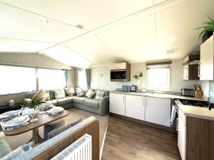 a kitchen and living room with a couch and a table at Dunlin Retreat in Flamborough