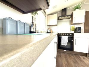 a kitchen with white cabinets and a counter top at Dunlin Retreat in Flamborough