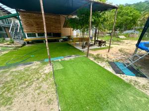 an image of a yard with a house at Lee Red House Homestay in Ban Ao Yai