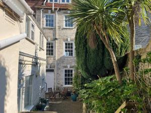 a courtyard of a house with a palm tree at Embassy in Weymouth