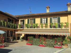 a yellow building with plants and flowers on it at Il Grappolo Vacanze in La Morra