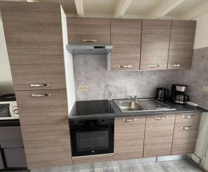 a small kitchen with wooden cabinets and a sink at Maison avec plage à pied in Saint-Georges-dʼOléron +7 photos