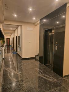 a hallway of a building with black marble floors at Srinivasa Paradise in Mahabalipuram