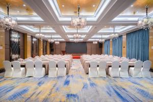 a large room with rows of tables and white chairs at 帝锦大酒店 in Supoqiao