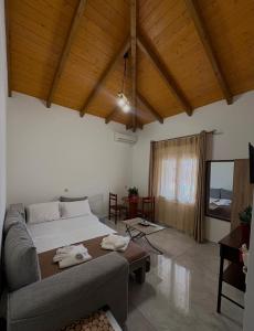 a bedroom with a bed and a couch and a tv at The Woodnest in Vonitsa