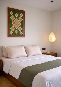 a bedroom with a large bed with a picture on the wall at Drop Inn Studios in Ahangama