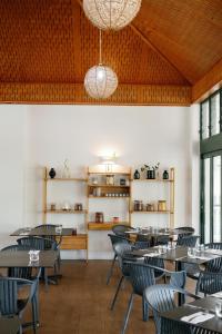 a dining room with tables and chairs and shelves at The Leea, Darwin in Darwin