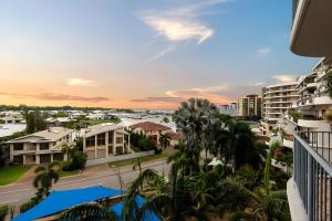 a view from the balcony of a resort with palm trees at Sunset Stunner Marina Views in Larrakeyah