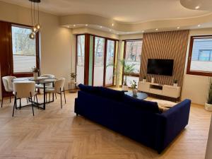 a living room with a blue couch and a table at Vallikraavi Old Town Apartment in Tartu