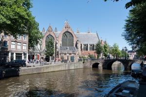 un barco en un río frente a una iglesia en RedLight District Apartment 1, en Ámsterdam