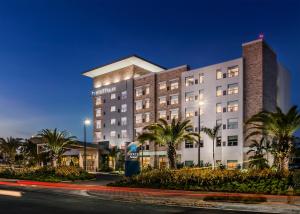 a hotel with palm trees in front of a building at Hyatt House San Juan in San Juan