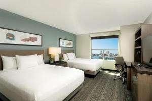 a hotel room with two beds and a desk at Hyatt House San Juan in San Juan