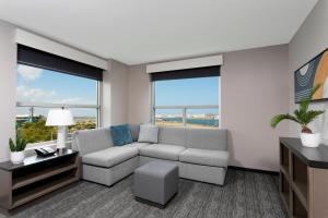 a living room with a couch and large windows at Hyatt House San Juan in San Juan