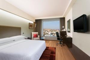 a hotel room with a bed and a large window at Four Points by Sheraton Jaipur, City Square in Jaipur