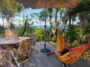 a person laying in a hammock on a deck at Les villas de Bagheera, oasis naturiste in Linguizzetta