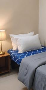 a bed with two pillows and a table with a lamp at The Nomad's Nest in New Delhi