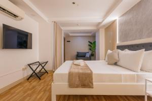 a bedroom with a white bed and a chair at Skypark Bay Hotel in Manila