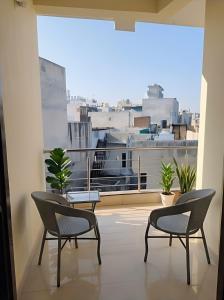 a balcony with two chairs and a view of a city at The Nomad's Nest in New Delhi