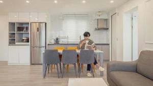 a person sitting at a table in a kitchen at Pohang Etoile Poolvilla in Pohang +5 photos