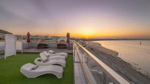 a row of white chairs on a balcony overlooking a beach at Pohang Etoile Poolvilla in Pohang