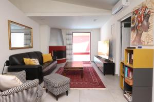 a living room with a couch and a table at The Bordeaux Door in Egina