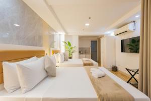 a bedroom with two beds with white pillows at Skypark Bay Hotel in Manila