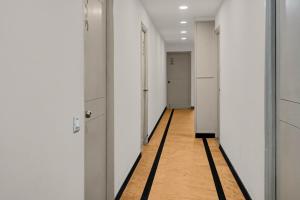 an empty hallway with white walls and a wooden floor at Super Townhouse Richmond MG Road Metro Formerly Richmond Residency in Bangalore