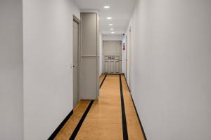 an empty hallway with white walls and a wooden floor at Super Townhouse Richmond MG Road Metro Formerly Richmond Residency in Bangalore