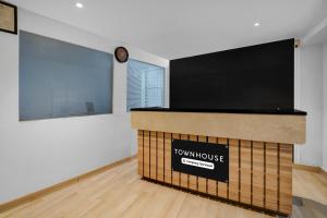 a room with a large television and a clock on the wall at Super Townhouse Richmond MG Road Metro Formerly Richmond Residency in Bangalore
