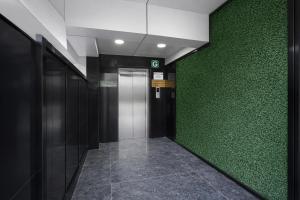a hallway with a green wall and a elevator at Super Townhouse Richmond MG Road Metro Formerly Richmond Residency in Bangalore