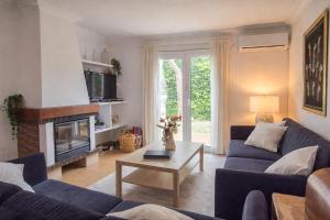 a living room with a blue couch and a fireplace at Bonito chalet en Valldemossa in Valldemossa