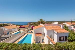 a villa with a swimming pool and the ocean at Villa Pearla by Villa Plus in Cala en Porter