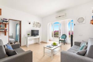 a living room with two couches and a tv at Villa Pearla by Villa Plus in Cala en Porter