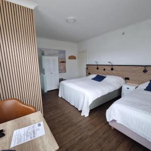 a hotel room with two beds and a chair at Hotel Montana in De Panne