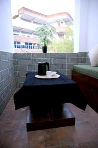 a table with a black table cloth and a plate with a coffeeucer at Panch Aarohan Hotel King in Pithorāgarh