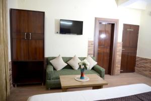 a living room with a green couch and a table at Panch Aarohan Hotel King in Pithorāgarh