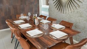 a wooden table with chairs and plates and wine glasses at The Cabana Oasis in Woorim