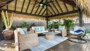 an outdoor patio with wicker chairs and a table at The Cabana Oasis in Woorim