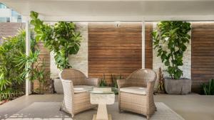 a patio with two chairs and a table and plants at The Cabana Oasis in Woorim