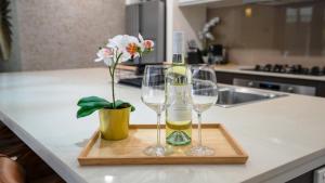 a bottle of wine and two wine glasses on a cutting board at The Cabana Oasis in Woorim