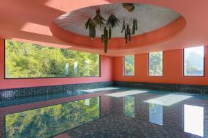 a swimming pool in a house with orange walls and windows at Yangshuo B&G Hotel-Exclusive location,Roof Top Viewing Terrace,Seasonal swimming pool,Free Self-Service Laundry & Drying, Entrance Ticket Serivce, Local Trip plan,E-Scooter& English Customer Service in Yangshuo