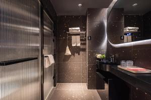 a bathroom with a sink and a mirror at Yangshuo B&G Hotel-Exclusive location,Roof Top Viewing Terrace,Seasonal swimming pool,Free Self-Service Laundry & Drying, Entrance Ticket Serivce, Local Trip plan,E-Scooter& English Customer Service in Yangshuo
