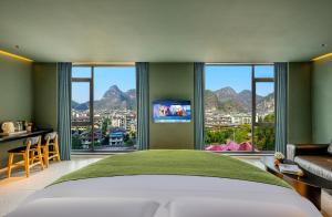 a bedroom with a large bed and a large window at Yangshuo B&G Hotel-Exclusive location,Roof Top Viewing Terrace,Seasonal swimming pool,Free Self-Service Laundry & Drying, Entrance Ticket Serivce, Local Trip plan,E-Scooter& English Customer Service in Yangshuo