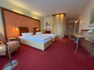 a hotel room with a large bed and a table at Hotel Ascot Bristol in Potsdam